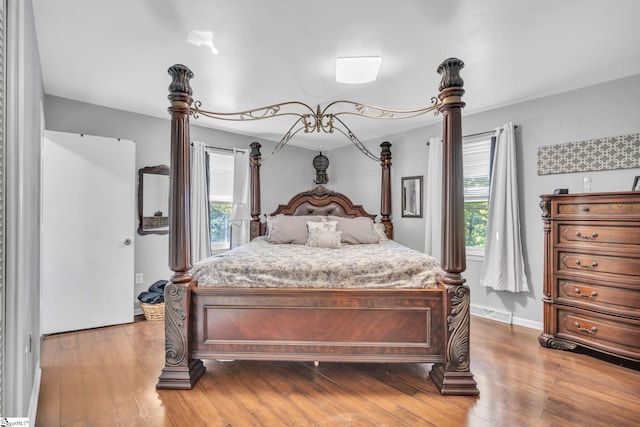 bedroom with visible vents, baseboards, and hardwood / wood-style flooring