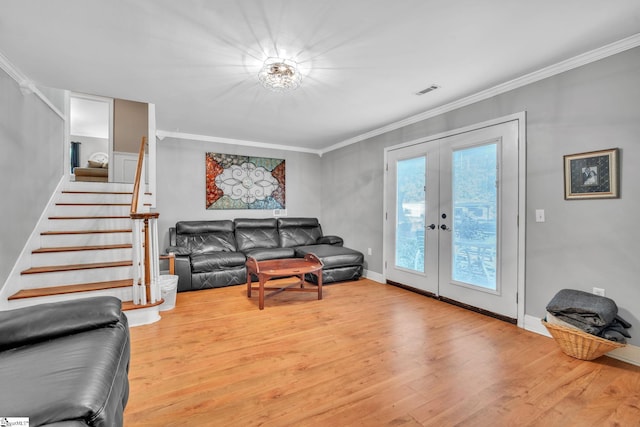 living room featuring stairway, french doors, crown molding, and wood finished floors