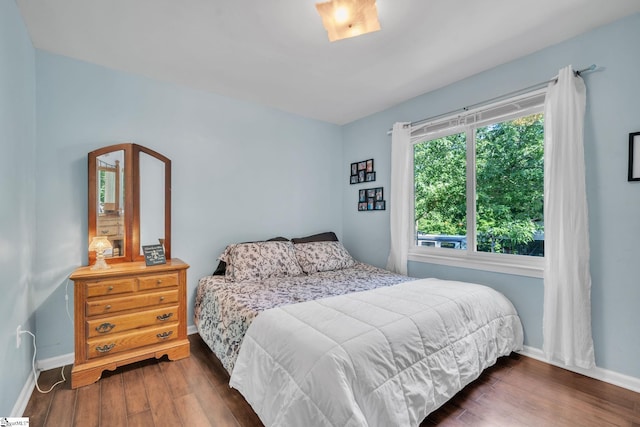 bedroom featuring baseboards and dark wood finished floors