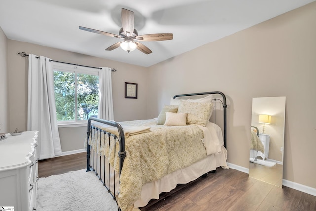 bedroom featuring a ceiling fan, dark wood-type flooring, and baseboards