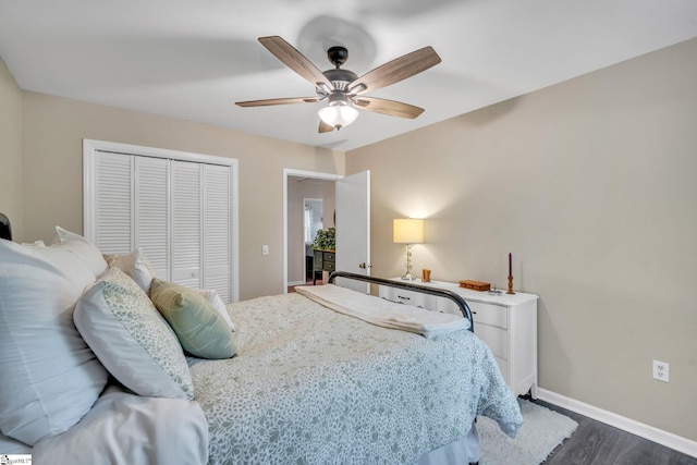 bedroom featuring dark wood finished floors, baseboards, a closet, and a ceiling fan