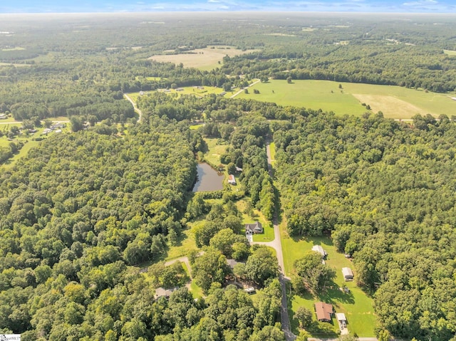 bird's eye view with a wooded view