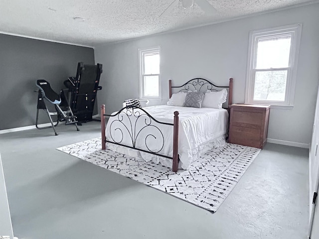 bedroom with finished concrete floors, multiple windows, and a textured ceiling