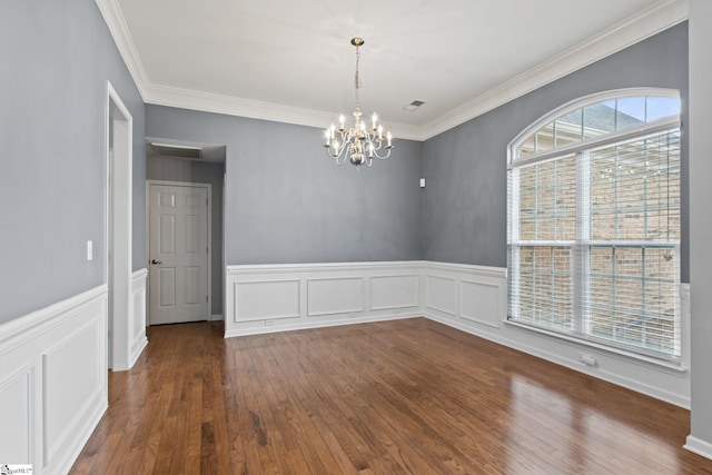 empty room featuring visible vents, crown molding, an inviting chandelier, and wood finished floors