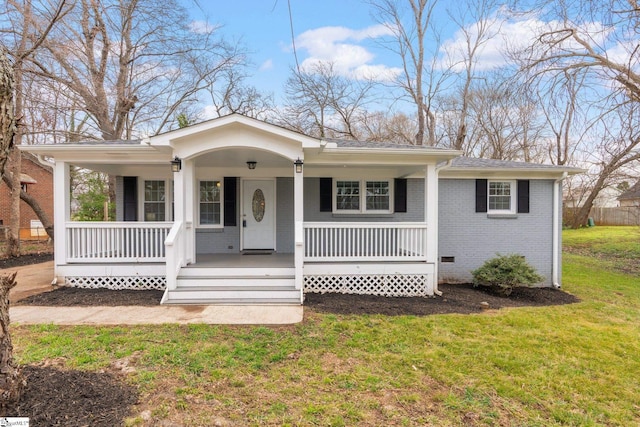 bungalow-style house featuring brick siding, covered porch, and a front lawn