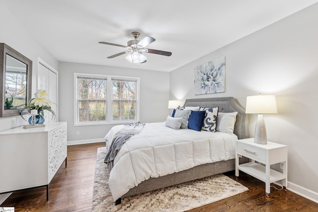 bedroom featuring baseboards, multiple windows, and dark wood-style floors