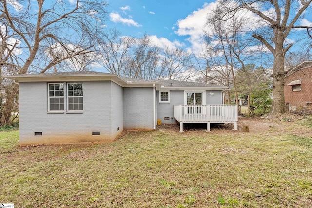 back of property featuring crawl space, a lawn, brick siding, and a deck