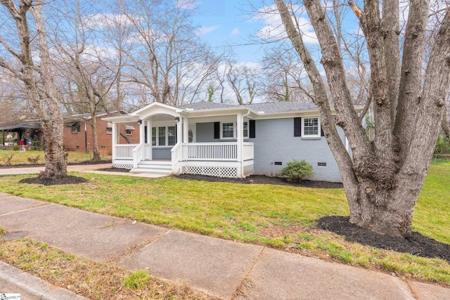 view of front of house with covered porch, a shingled roof, a front lawn, crawl space, and brick siding