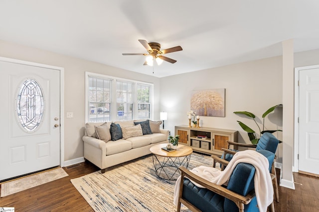 living area featuring dark wood-style floors, baseboards, and ceiling fan