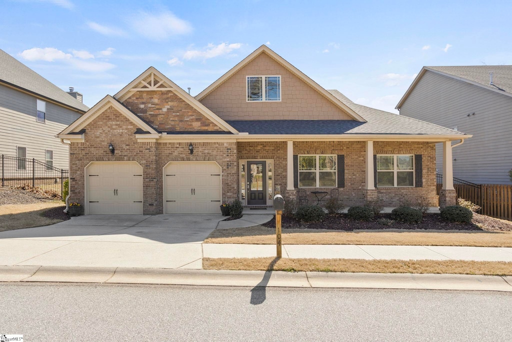 104 Downey Hill Ln, Greer, SC 29650 - craftsman-style home with driveway, fence, an attached garage, a shingled roof, and brick siding