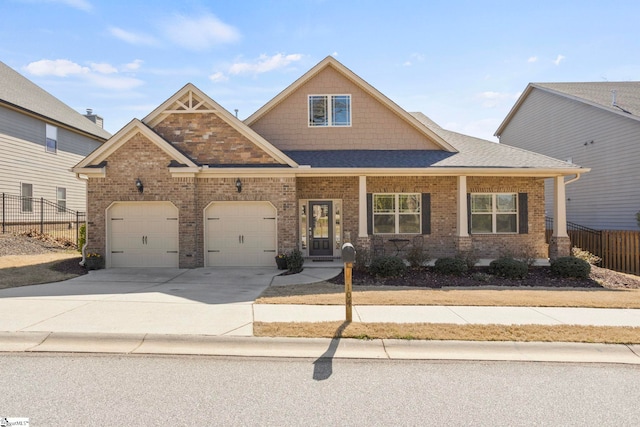 craftsman-style home with driveway, fence, an attached garage, a shingled roof, and brick siding