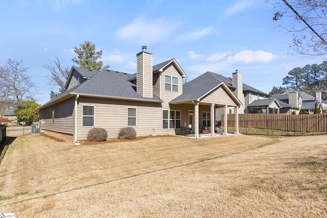 back of property with a patio, a yard, and fence