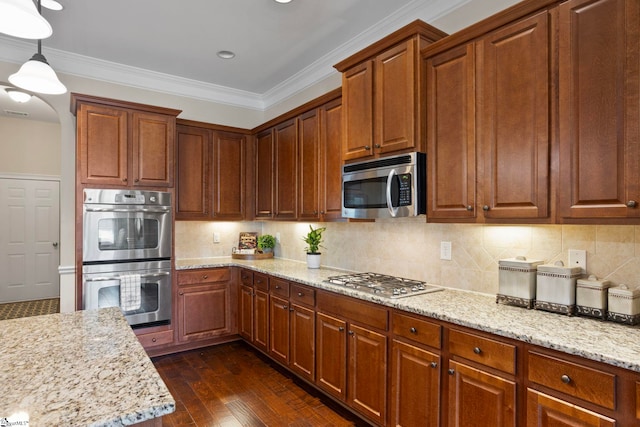 kitchen with light stone countertops, dark wood finished floors, ornamental molding, decorative backsplash, and stainless steel appliances