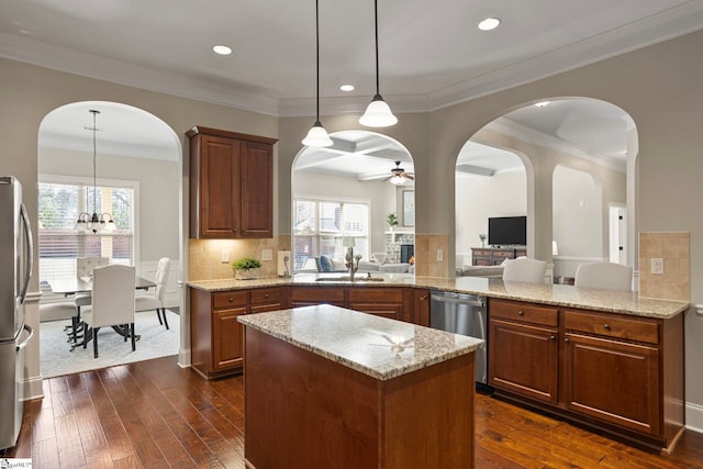 kitchen featuring a ceiling fan, a peninsula, dark wood-style flooring, a sink, and appliances with stainless steel finishes