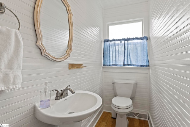 bathroom featuring wood finished floors, toilet, visible vents, and a sink