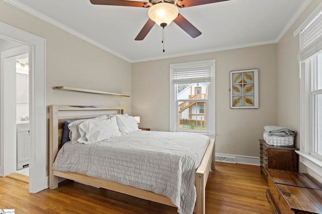 bedroom with visible vents, crown molding, and wood finished floors