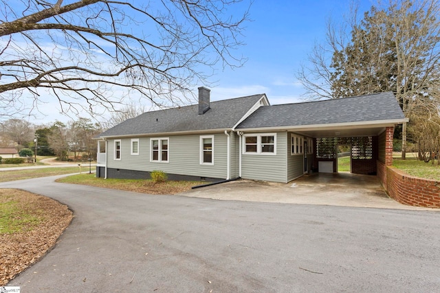 exterior space featuring a shingled roof, a chimney, a carport, crawl space, and aphalt driveway