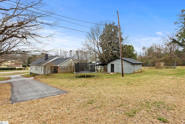 view of yard featuring an outbuilding and a trampoline