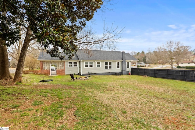 rear view of house with crawl space, a shingled roof, a yard, and fence