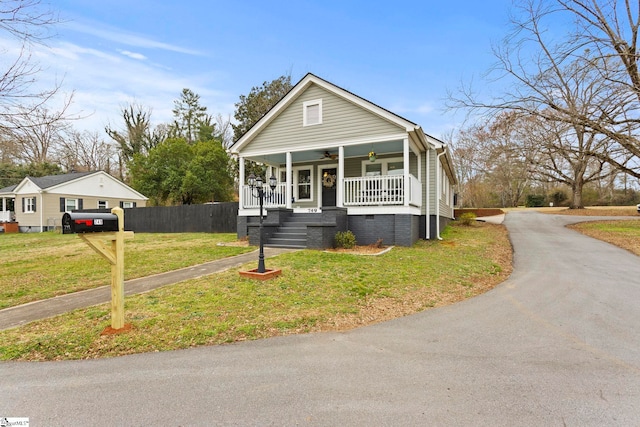 view of front of property featuring driveway, a front lawn, a porch, crawl space, and ceiling fan