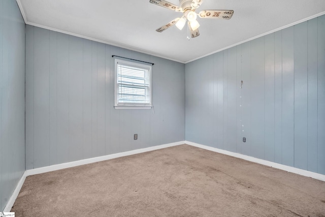 empty room with ceiling fan, baseboards, carpet, and ornamental molding