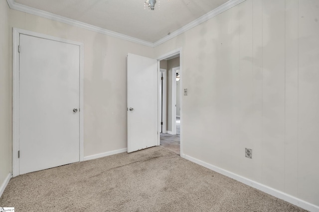 unfurnished bedroom with carpet flooring, crown molding, and baseboards