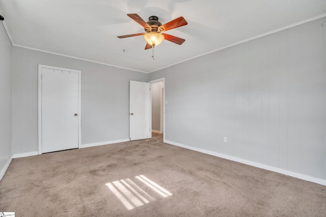 unfurnished bedroom with baseboards, carpet floors, ornamental molding, and a ceiling fan