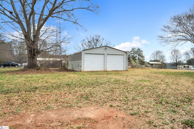 view of yard with a detached garage, an outdoor structure, and fence