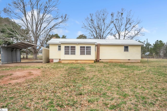 rear view of house with driveway, a carport, crawl space, a lawn, and metal roof