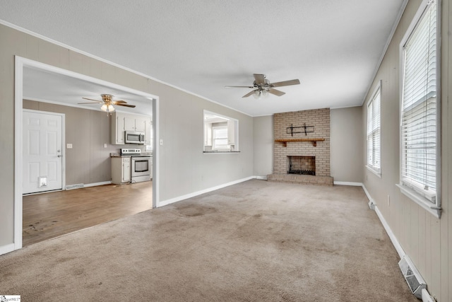 unfurnished living room with crown molding, a ceiling fan, and light carpet