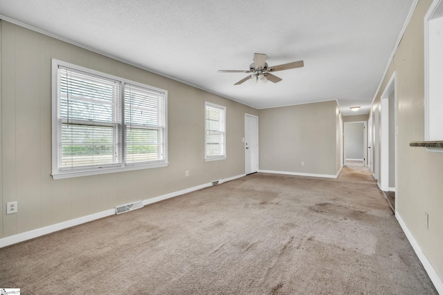 unfurnished living room with visible vents, ornamental molding, a textured ceiling, carpet, and ceiling fan