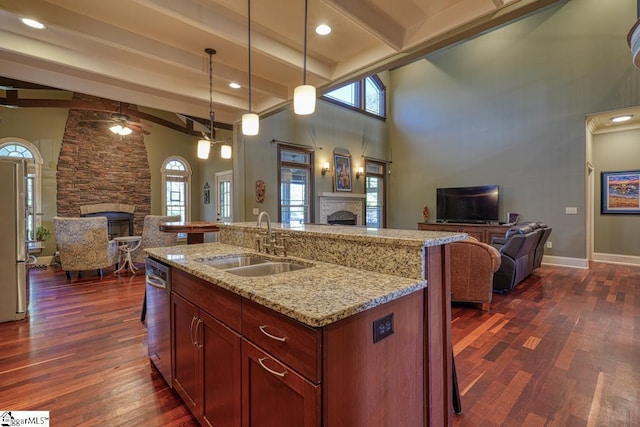 kitchen featuring appliances with stainless steel finishes, open floor plan, a fireplace, and a sink