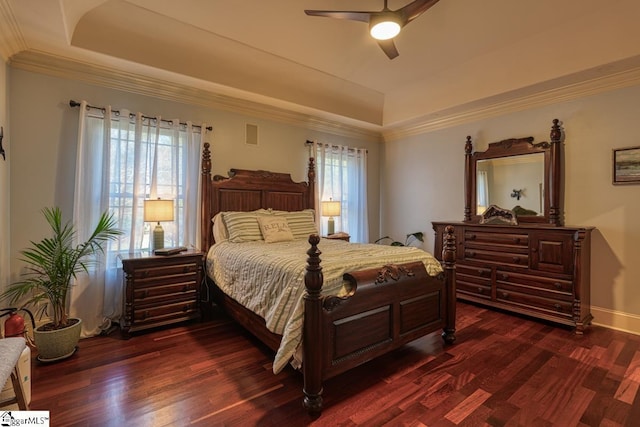 bedroom with a raised ceiling, dark wood-type flooring, and ornamental molding