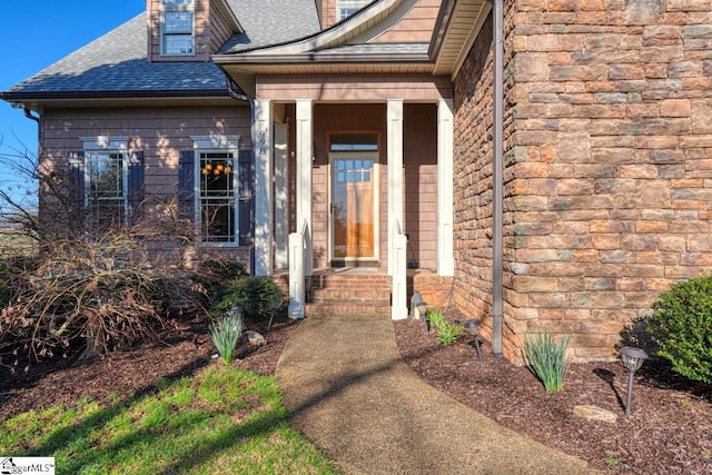 doorway to property with roof with shingles