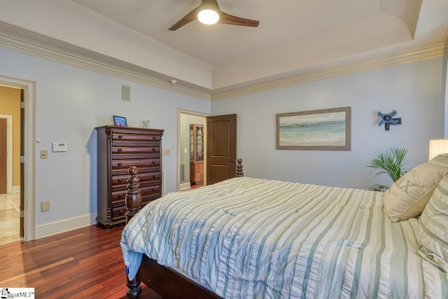 bedroom featuring visible vents, ornamental molding, wood finished floors, baseboards, and ceiling fan