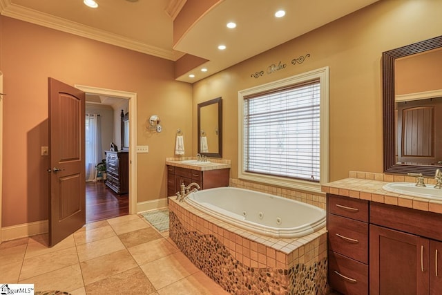 full bath with crown molding, two vanities, a whirlpool tub, and a sink