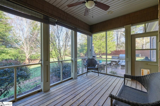 unfurnished sunroom featuring a ceiling fan