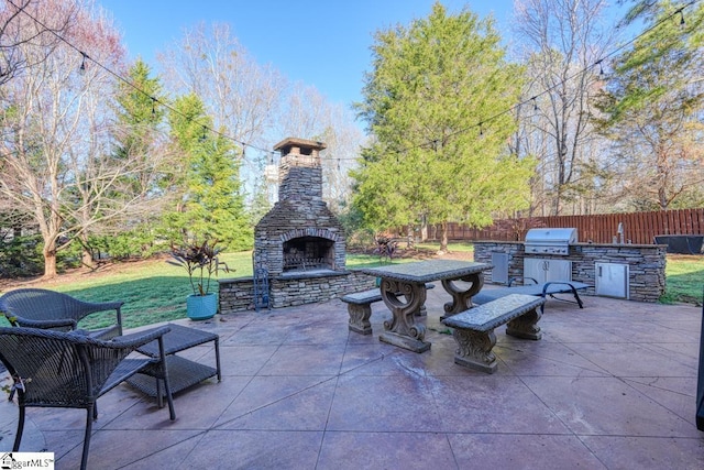 view of patio / terrace with a grill, exterior kitchen, an outdoor stone fireplace, and fence