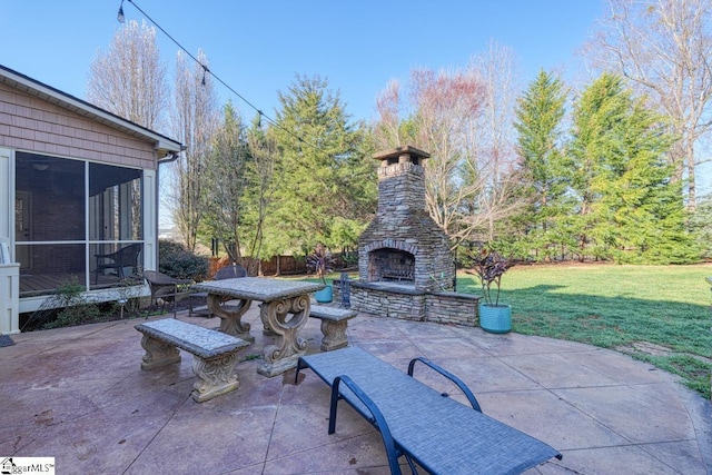 view of patio / terrace with a sunroom and an outdoor stone fireplace