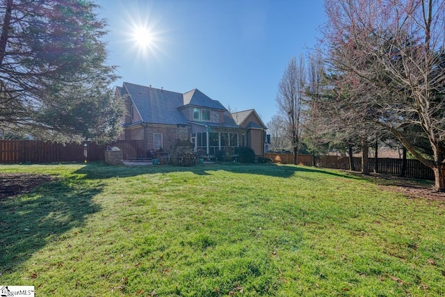 back of house with a fenced backyard and a yard