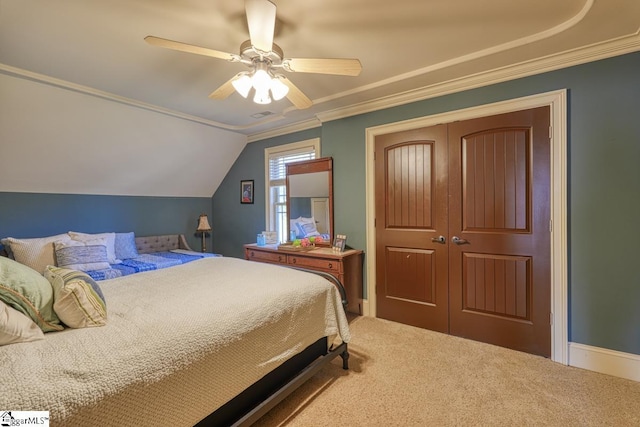 bedroom featuring a closet, carpet floors, crown molding, lofted ceiling, and ceiling fan