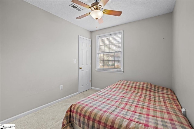 bedroom with visible vents, baseboards, carpet, a textured ceiling, and a ceiling fan