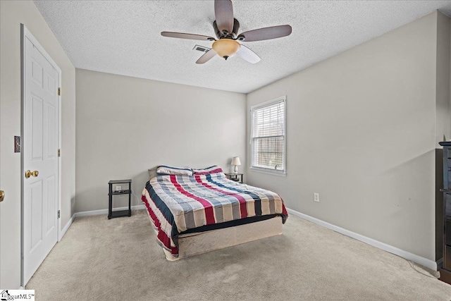 carpeted bedroom with a textured ceiling, visible vents, baseboards, and ceiling fan