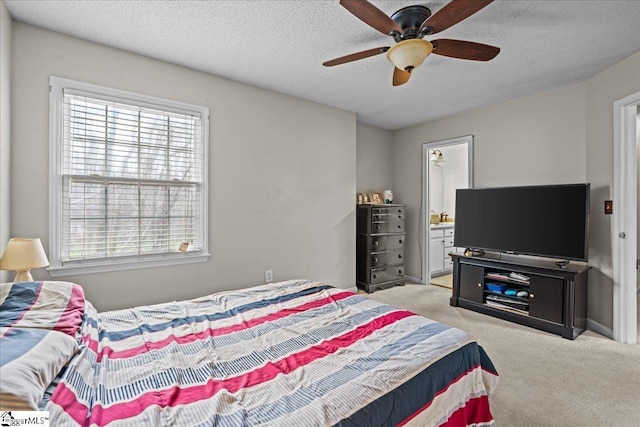 carpeted bedroom featuring ensuite bath, a ceiling fan, baseboards, and a textured ceiling