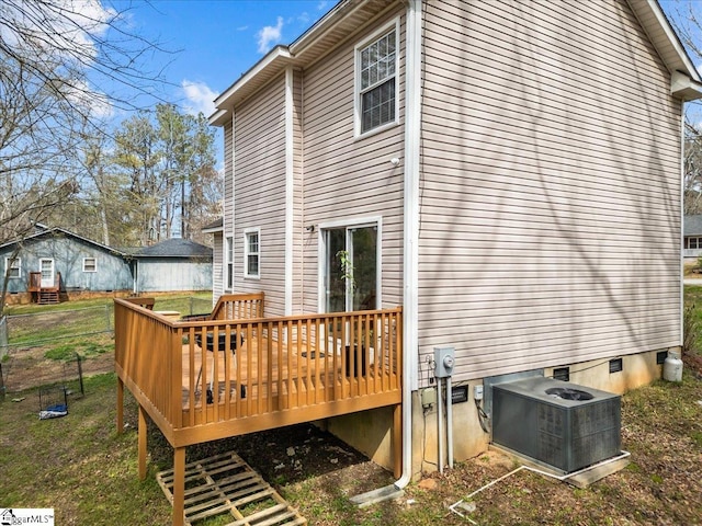 rear view of property with central AC unit, a wooden deck, and a yard