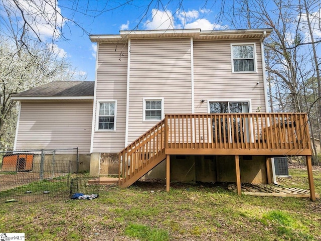 back of house with a wooden deck, a yard, stairs, and fence