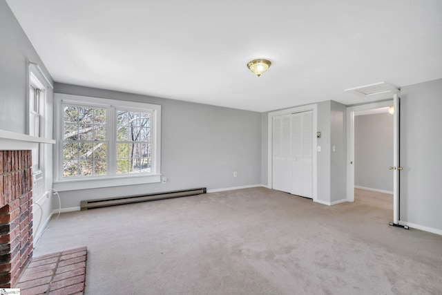 unfurnished living room featuring a baseboard heating unit, attic access, carpet flooring, and baseboards