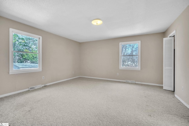 unfurnished room with carpet flooring, baseboards, and visible vents