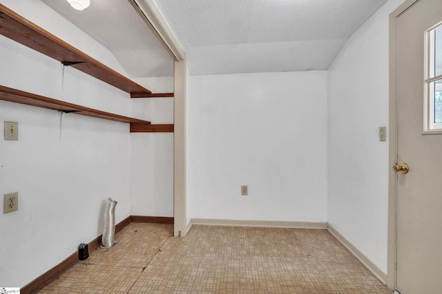 washroom featuring tile patterned floors, a textured ceiling, and baseboards