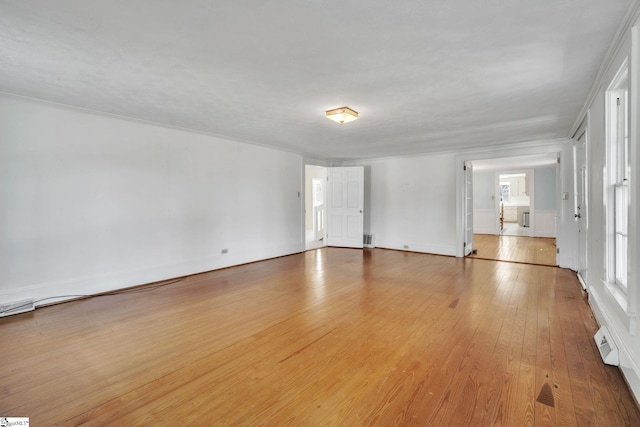 spare room featuring visible vents, light wood-style floors, and crown molding